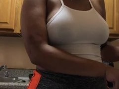 Busty young black girl is making food in kitchen and shaking tits